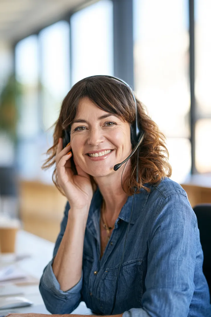 Customer care specialist wearing a headset at a bright support desk, ready to answer loan instant cash funding questions